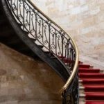 Escalier en colimacon avec rampe en fer forge dans un immeuble ancien parisien